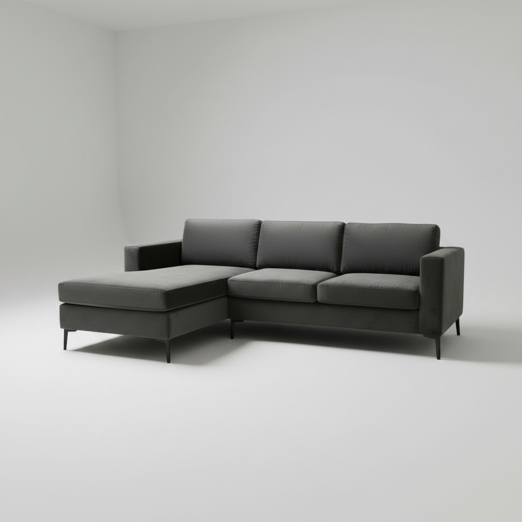 A modern dark gray L-shaped sectional sofa with a chaise lounge on the left side, shown in a minimalist studio setting with a light gray background.