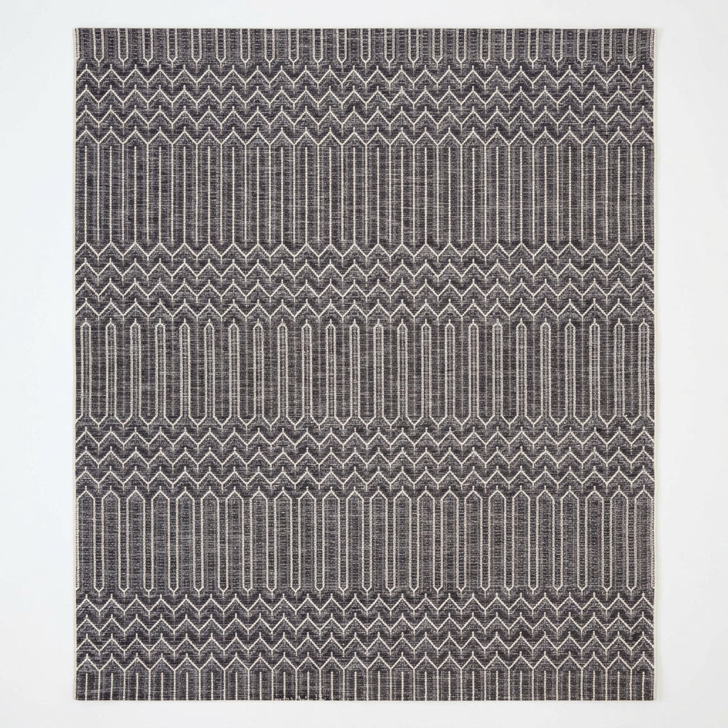 Textured patterned fabric with a zigzag design in black and white.