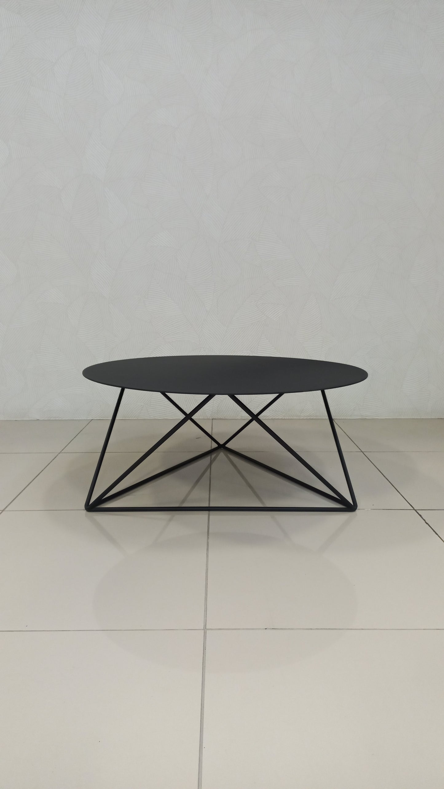 Elements Coffee Table with round black steel top and geometric frame.