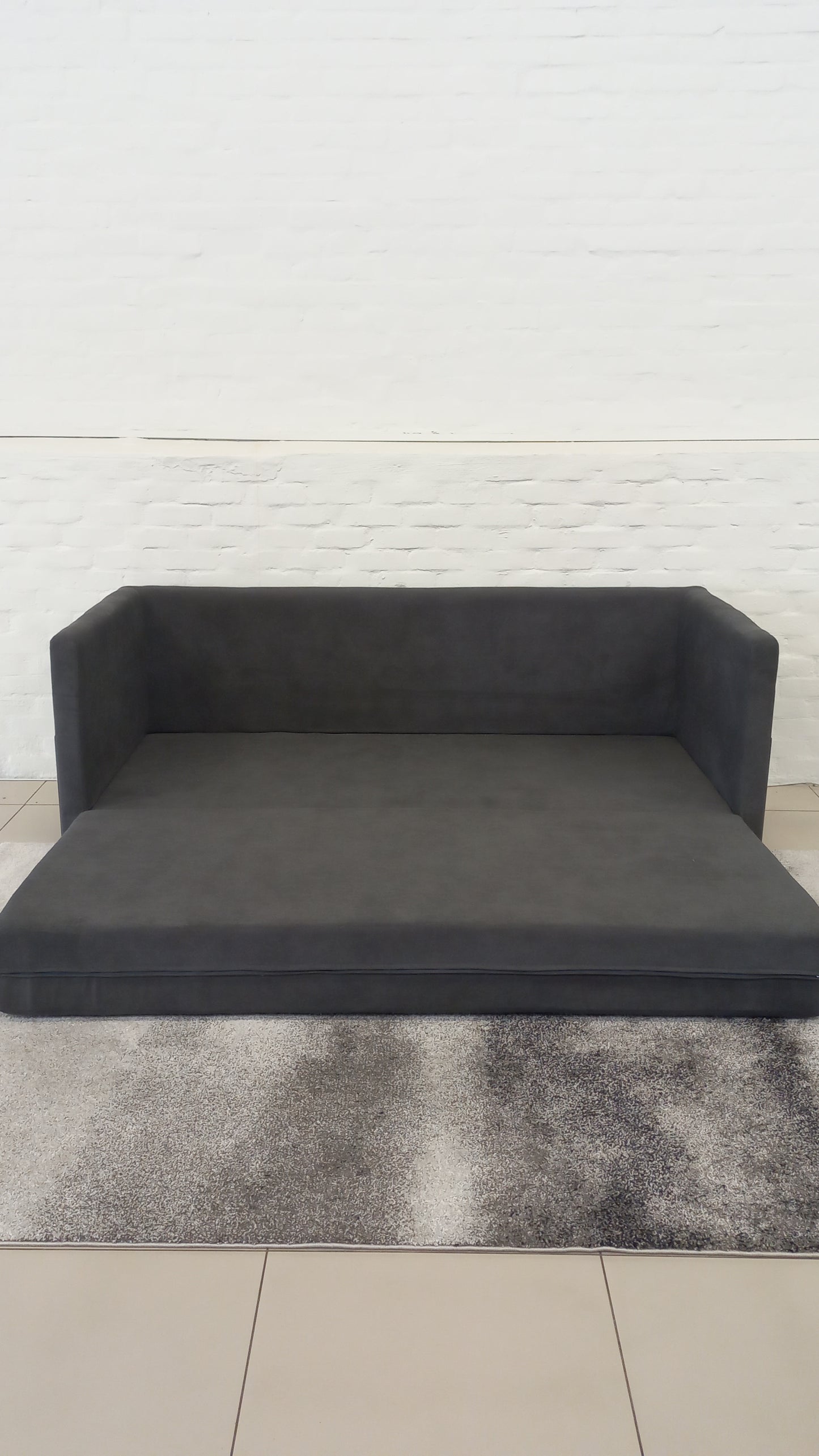 Close-up of the Mojo Sleeper Couch, highlighting its steel frame and customizable upholstery.