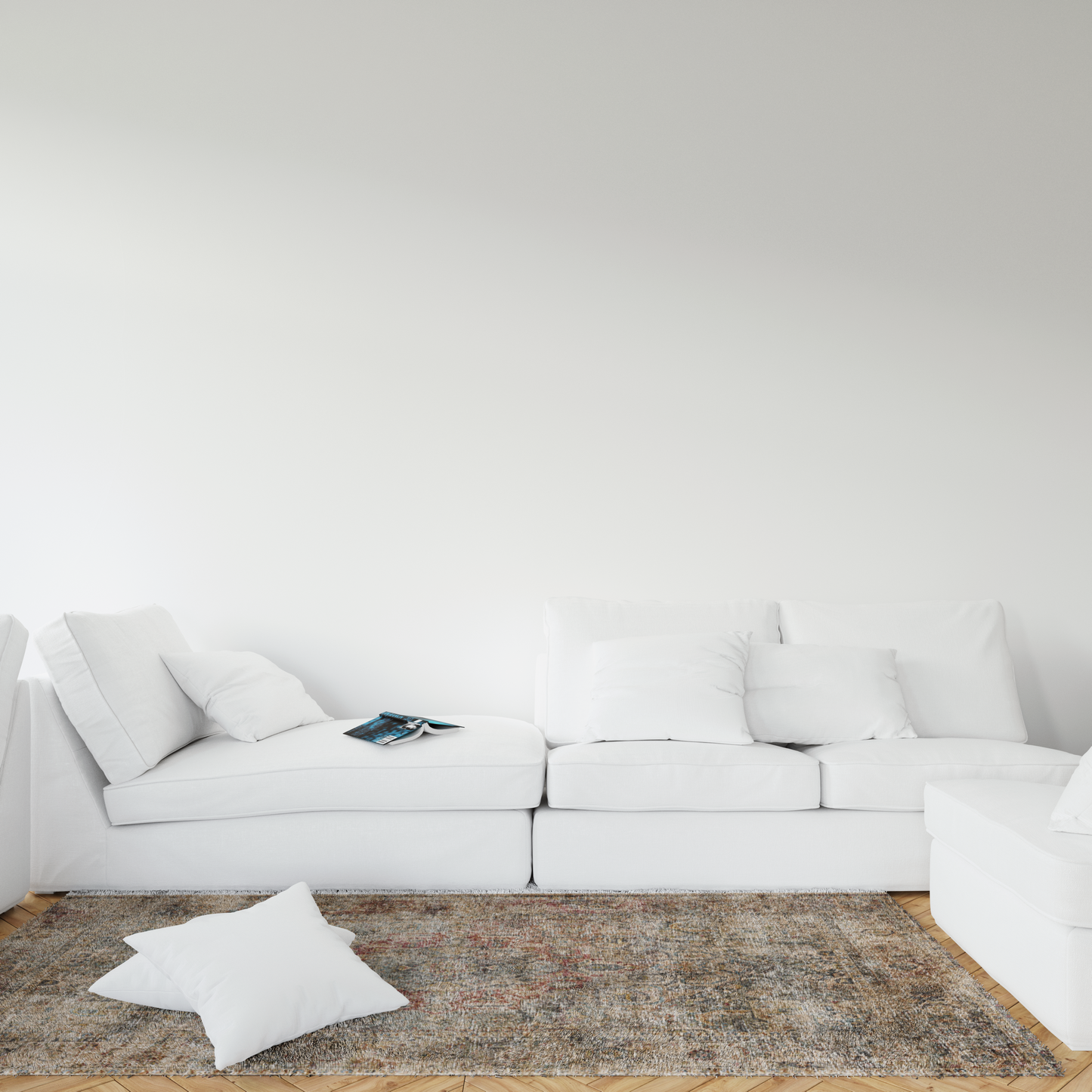 White sectional sofa with cushions on a textured rug against a white wall