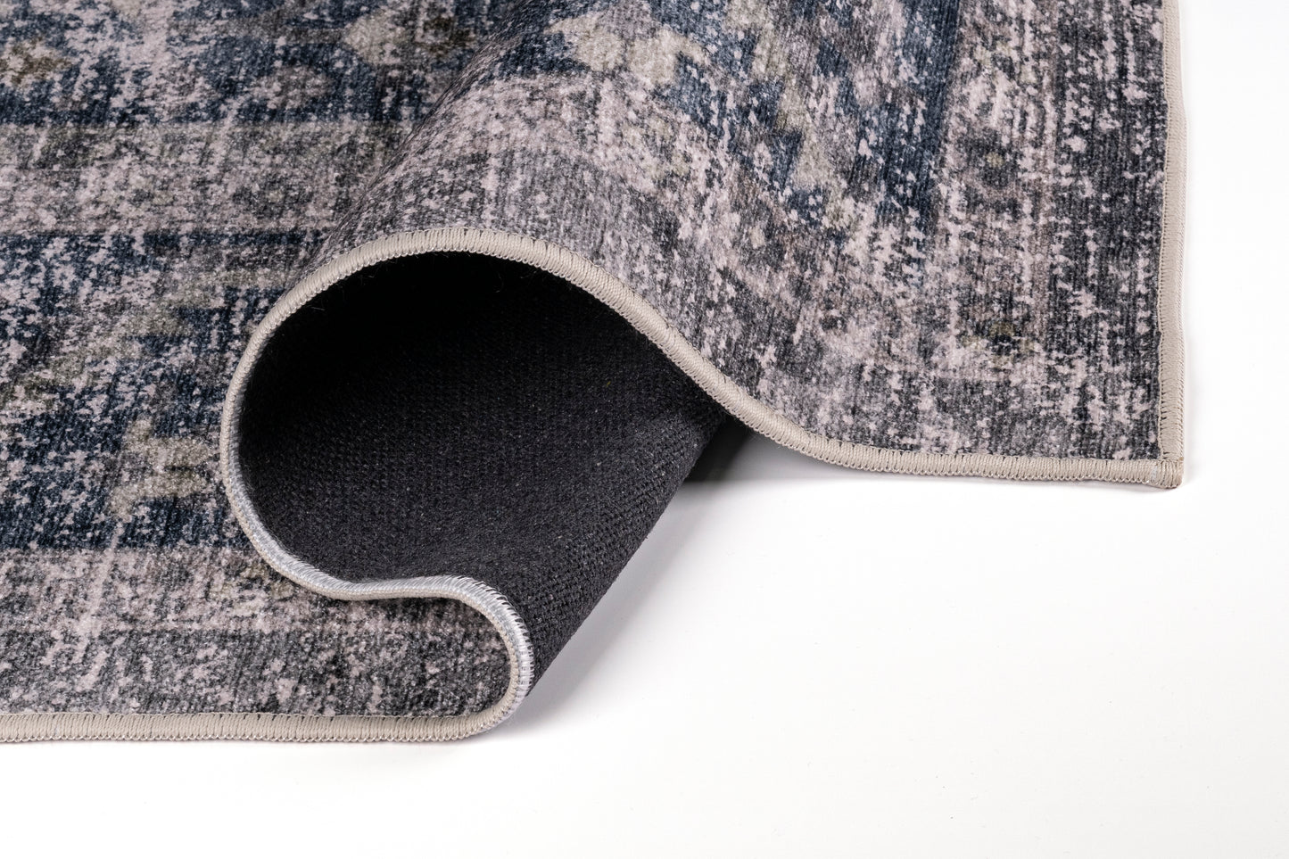 Close-up of a textured rug with a rolled edge on a white background