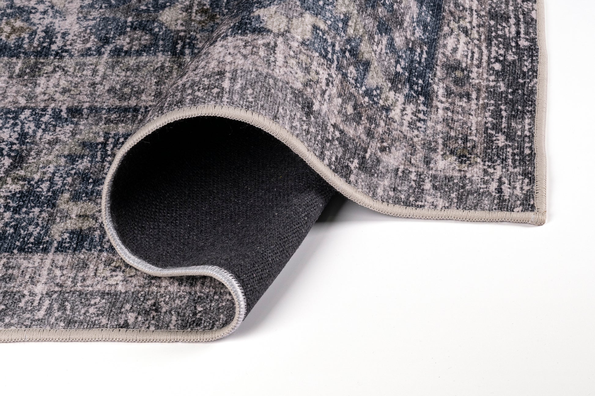 Close-up of a textured rug with a rolled edge on a white background