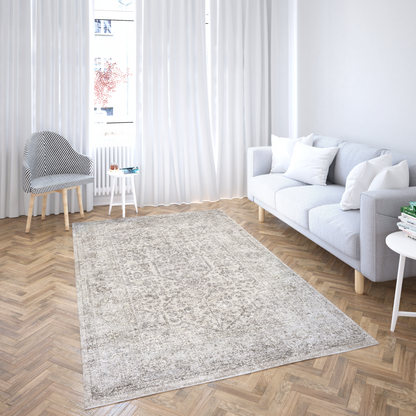 Living room with a gray rug, white sofa, and wooden floor.
