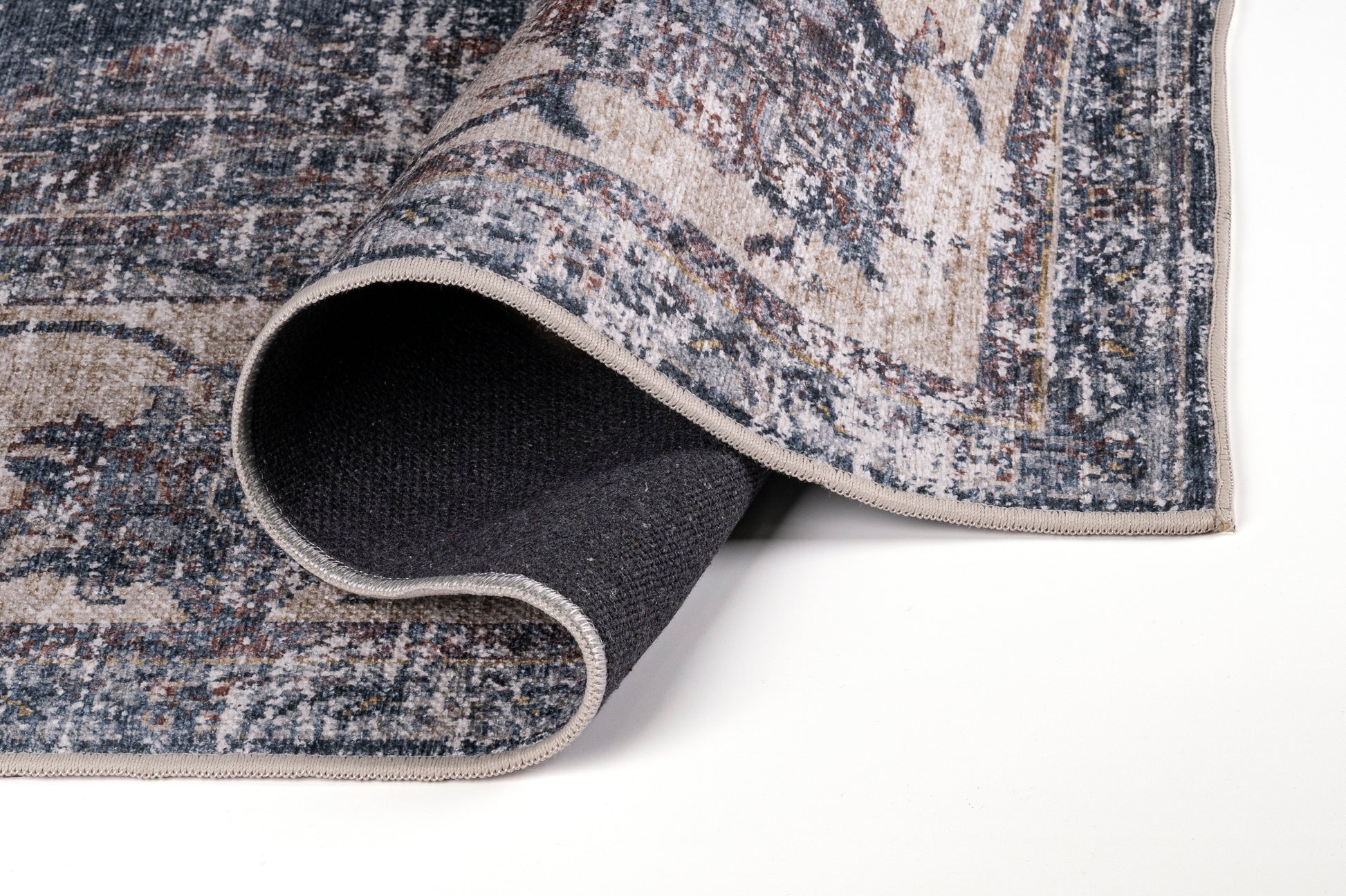 Close-up of a textured rug corner on a white background