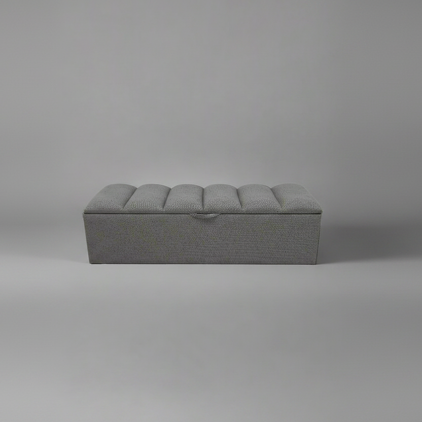 Gray upholstered bench on a plain gray background