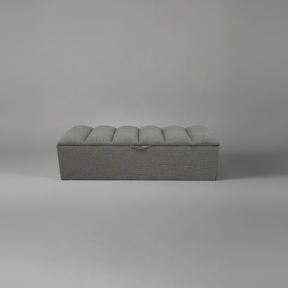 Gray upholstered bench on a plain gray background