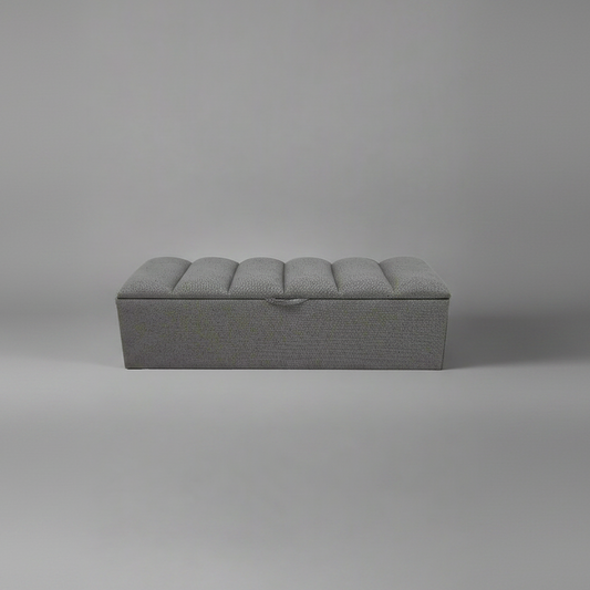 Gray upholstered bench on a plain gray background