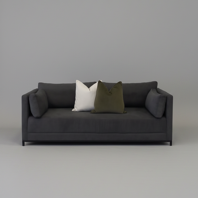 Dark gray sleeper couch sofa with two pillows on a plain background