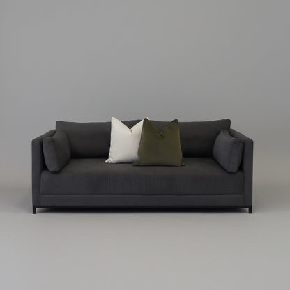 Dark gray sleeper couch sofa with two pillows on a plain background