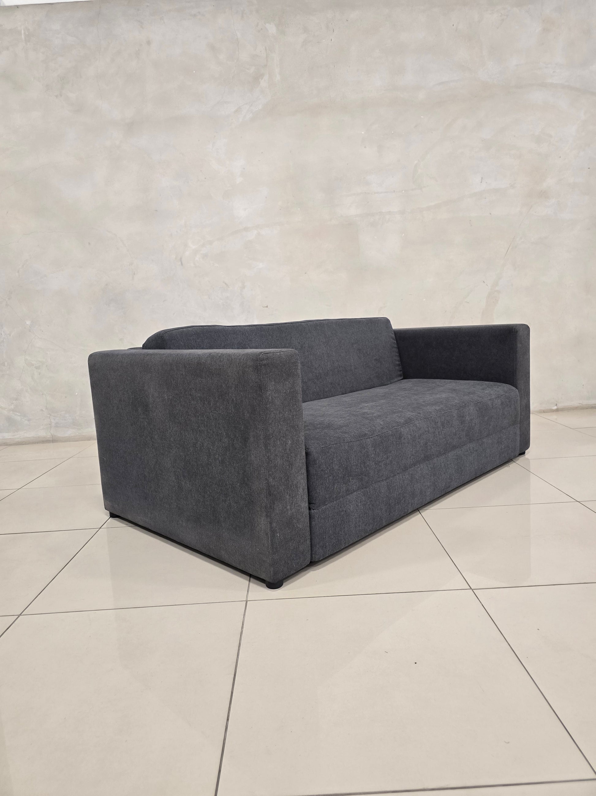 Modern couch that converts to bed, with sleek minimalist design.