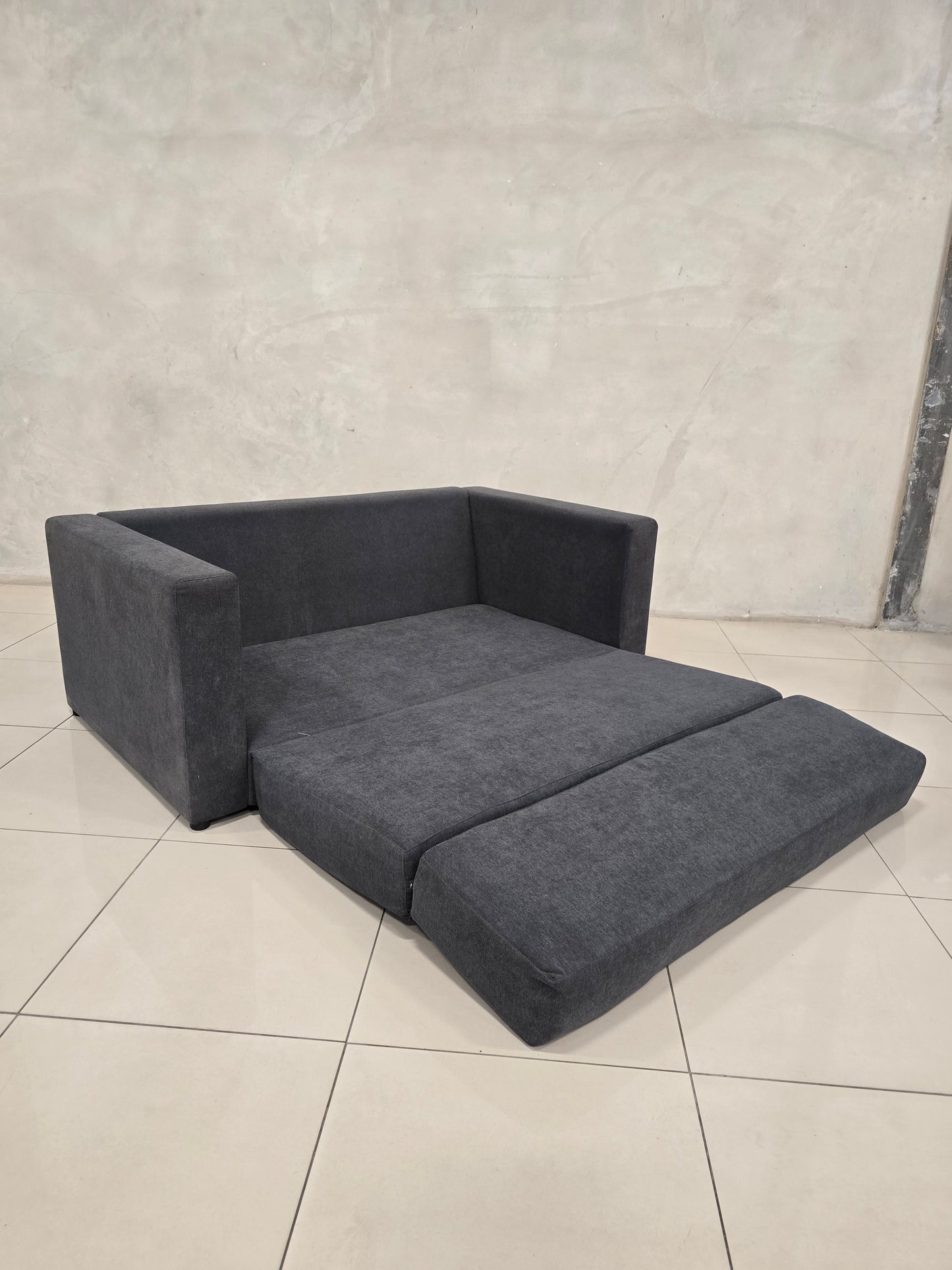 Modern couch that converts to bed, with sleek minimalist design.