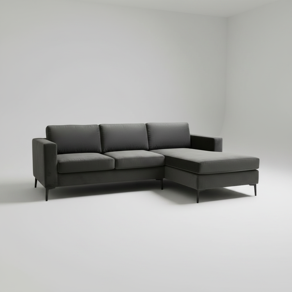 A modern dark gray sectional sofa with a right-facing chaise lounge, shown in a minimalist studio setting with a light gray background.