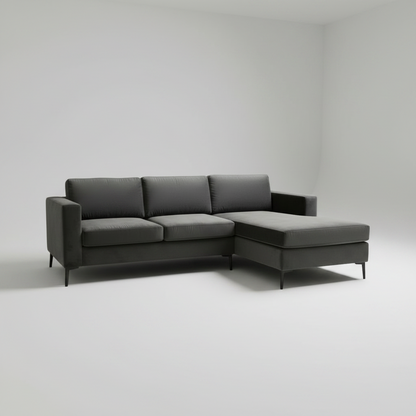 A modern dark gray sectional sofa with a right-facing chaise lounge, shown in a minimalist studio setting with a light gray background.