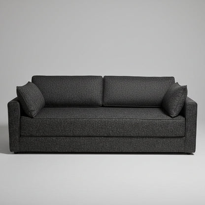 A dark gray textured fabric loveseat sofa with two matching back cushions, positioned in a retail showroom with baby furniture and bedding visible in the background.