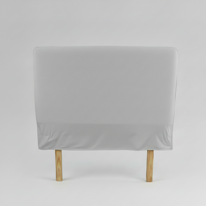 Gray slipcover headboard on a wooden chair against a grey background