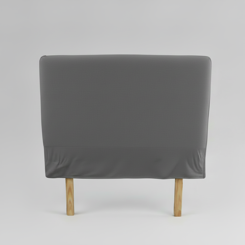 Gray upholstered slip cover headboard with wooden legs on a light grey background