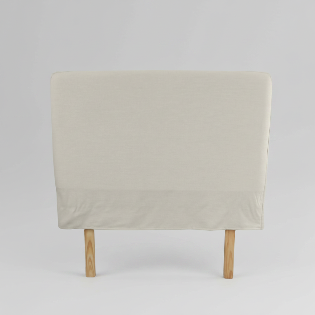 Beige slipcover headboard with wooden legs on a light grey background
