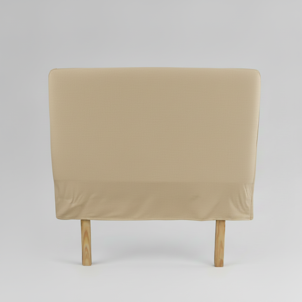 Beige slipcover headboard on a wooden bed frame against a gray background