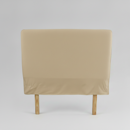 Beige slipcover headboard on a wooden bed frame against a gray background