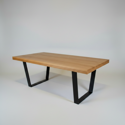Wooden table with black metal legs on a plain background