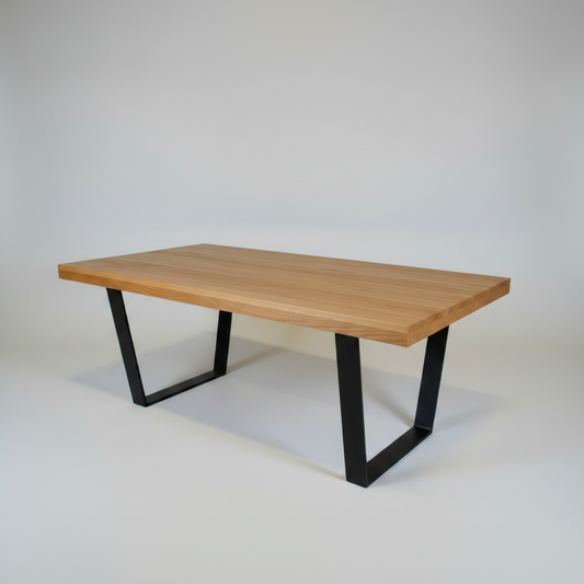 Wooden table with black metal legs on a plain background