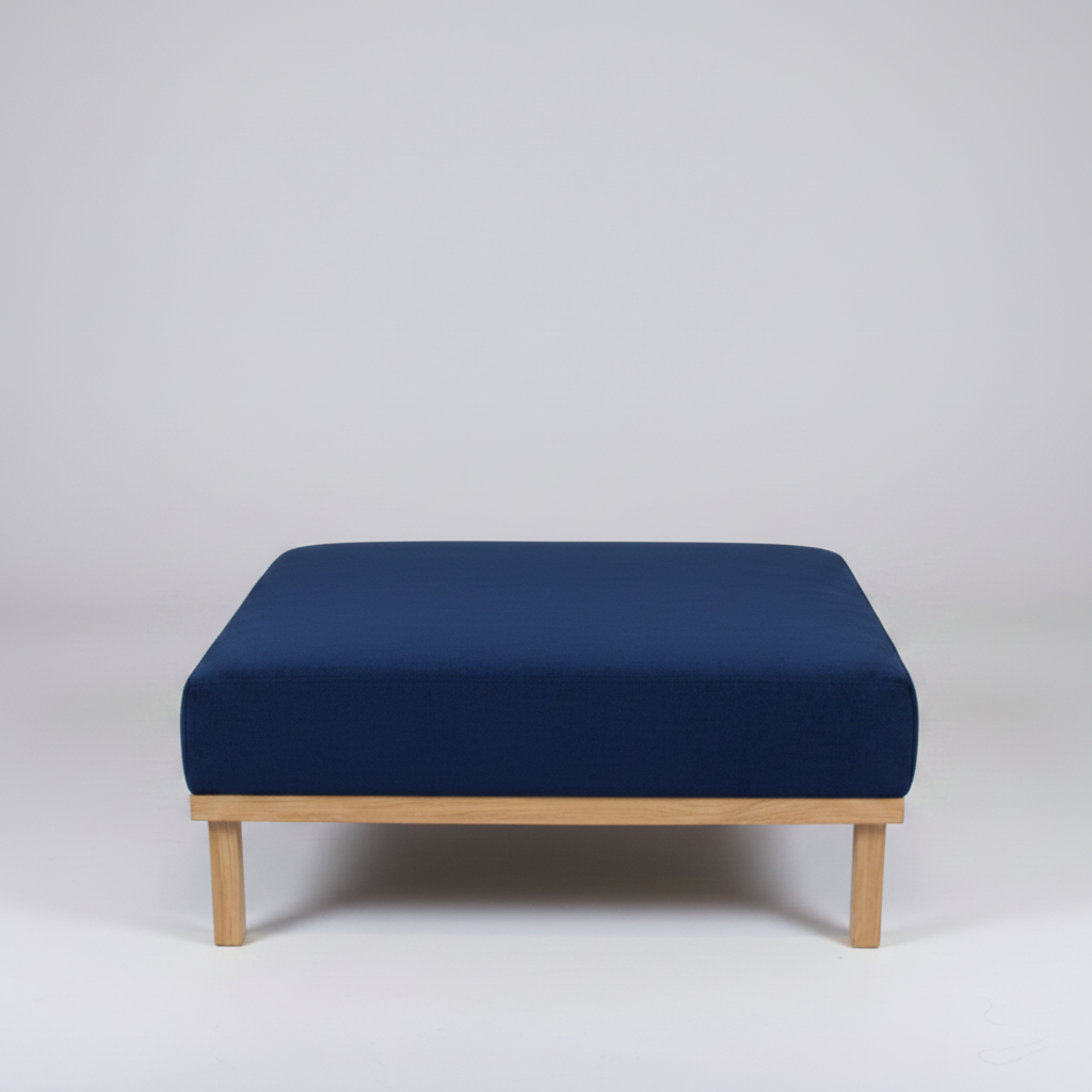 Navy blue ottoman with wooden legs on a light gray background