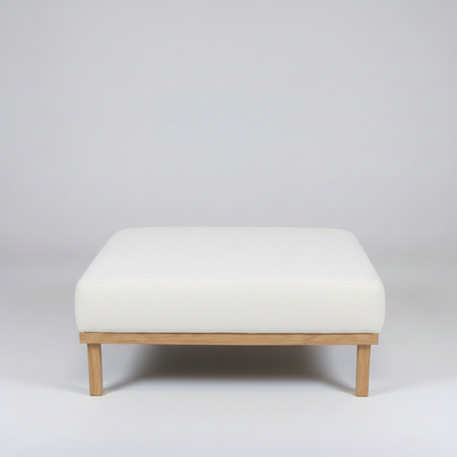 White ottoman with wooden legs on a light gray background