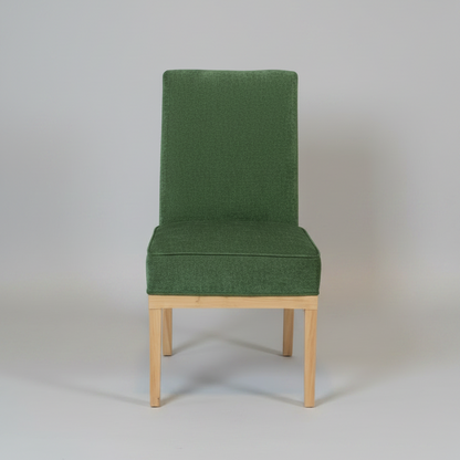 Green upholstered chair with wooden legs on a plain background
