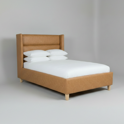 Brown upholstered bed with white mattress and pillows on a gray background