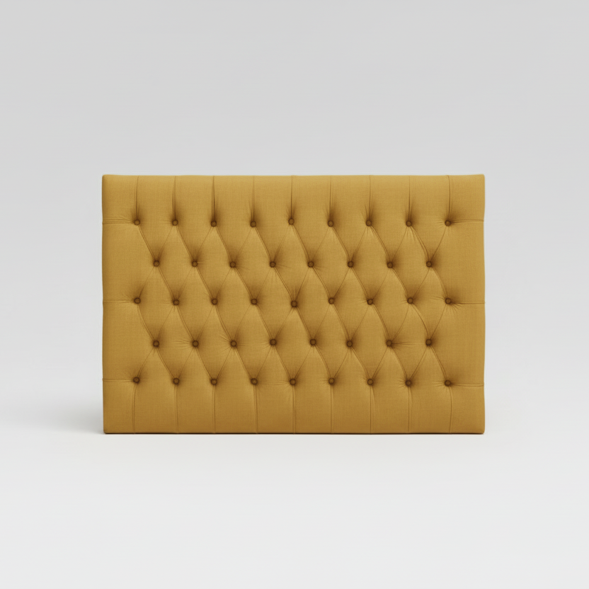 Mustard yellow tufted headboard on a white background