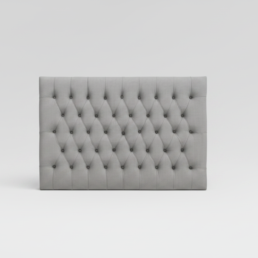 Gray tufted headboard on a white background