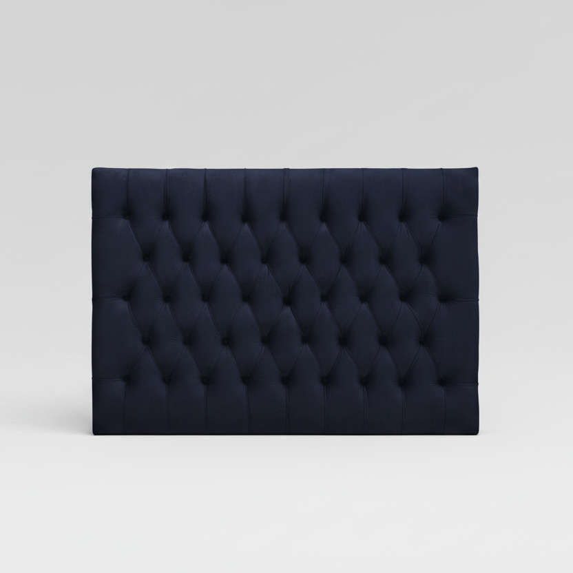 Navy tufted headboard on a light gray background