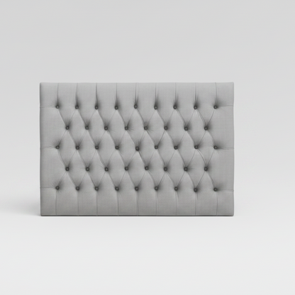 Gray tufted headboard on a white background