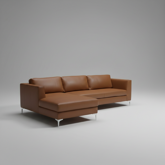 A modern sectional sofa with a left-facing chaise lounge, upholstered in smooth tan leather, shown on a neutral gray studio background.