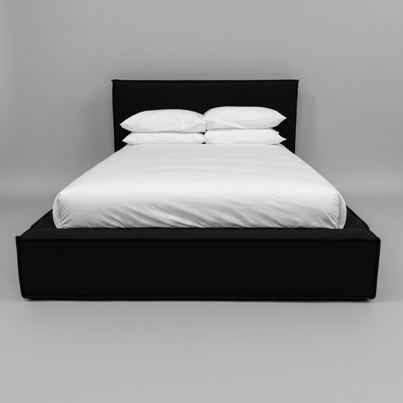 Black bed frame with white bedding against a beige wall.