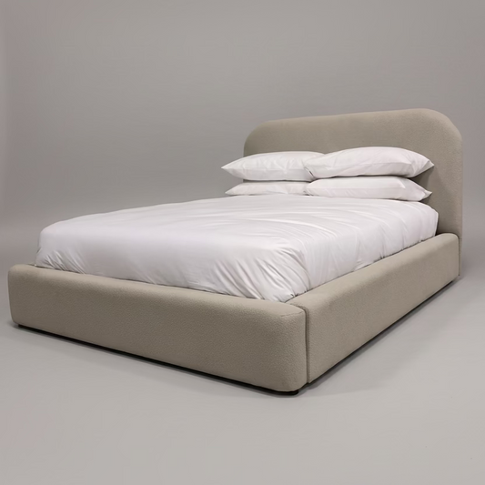 Beige bed with white bedding against a gray background