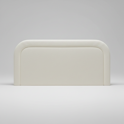 Beige upholstered headboard on a white bed with a light gray background