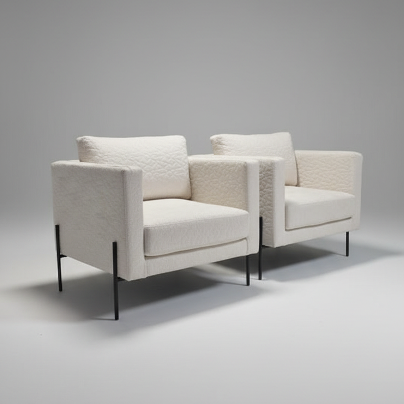 Two white armchairs with black legs on a gray background