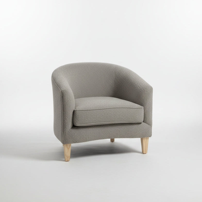 Gray armchair in a modern living room setting with decor elements.