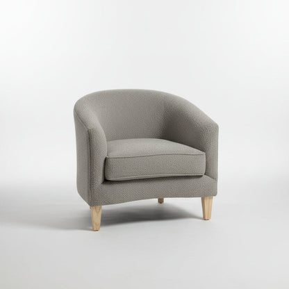 Gray armchair in a modern living room setting with decor elements.