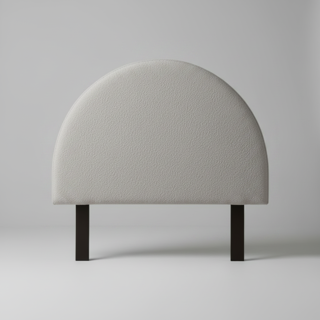 Half moon headboard in grey cushion on a stand against a plain background