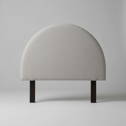 Half moon headboard in grey cushion on a stand against a plain background