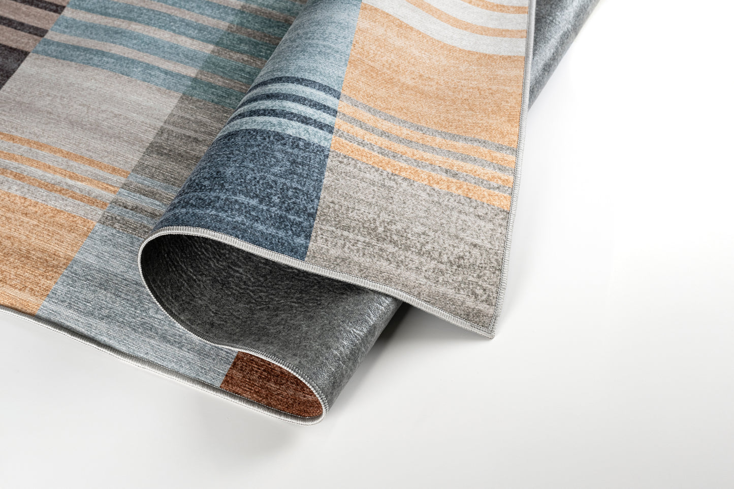 Close-up of a patterned rug with brown, blue, and gray colors on a white background.