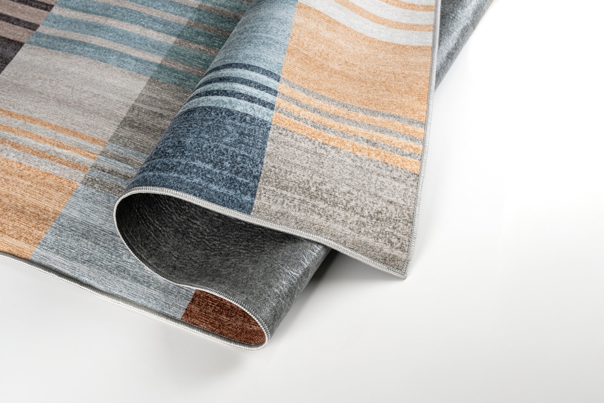 Close-up of a patterned rug with brown, blue, and gray colors on a white background.