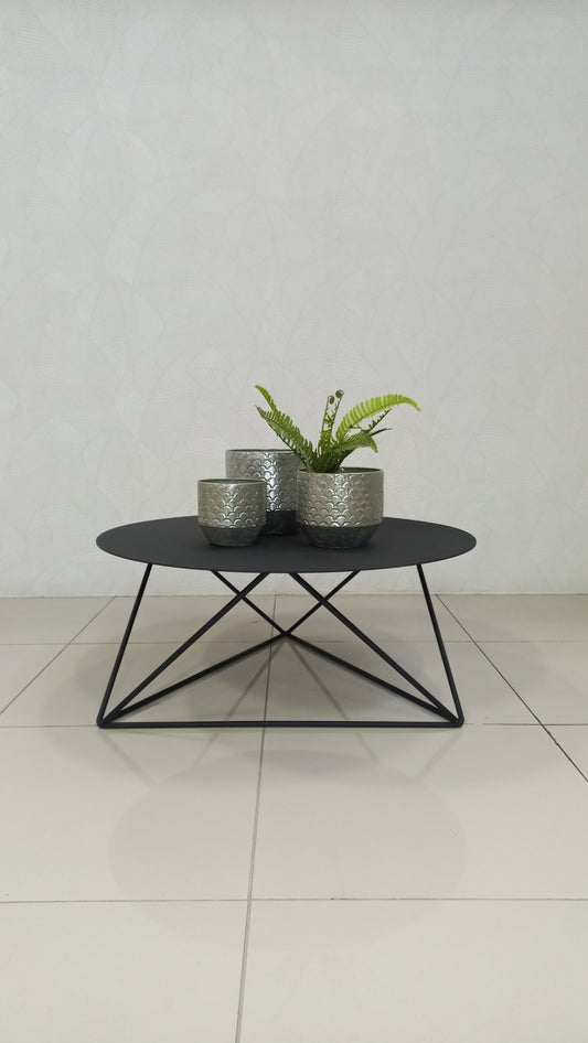 Elements Coffee Table with round black steel top and geometric frame.