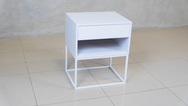 Minimalist white bedside table featuring an epoxy-coated steel frame and sleek design.