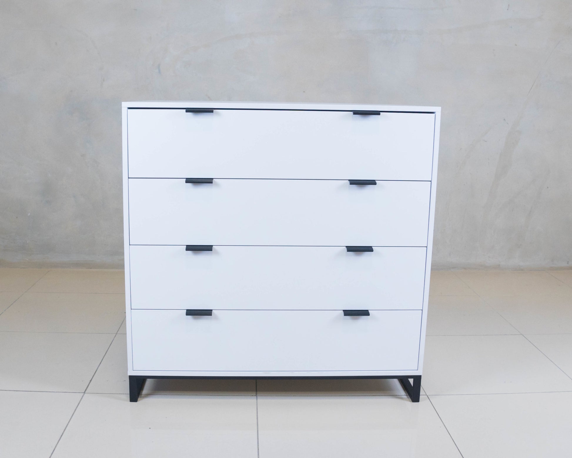 Sleek Chest of Drawers in white melamine with black handles.