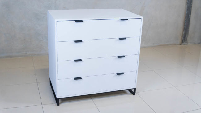 Sleek Chest of Drawers in white melamine with black handles.